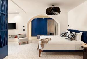 a bedroom with a bed and a blue wall at LYO II Boutique Suites in Mikonos