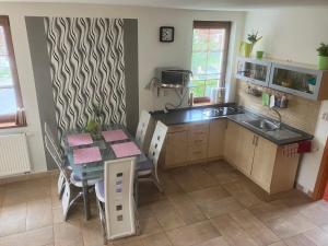 a kitchen with a table and a dining room at Kašperky Apartmány in Kašperské Hory
