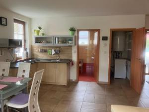 a kitchen with a counter and a table with chairs at Kašperky Apartmány in Kašperské Hory +15 photos