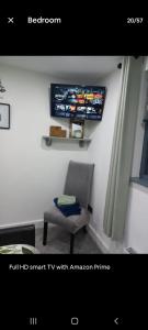 a room with a chair and a tv on the wall at Dunfolan House in Dundrum +1 photo