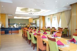 a dining room with wooden tables and chairs at City Seasons Hotel & Suites Muscat in Muscat