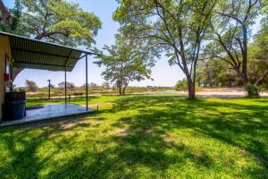 a picnic shelter in a field with trees at Zambezi Mubala Campsite in Katima Mulilo