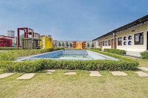a swimming pool in a park next to a building at Hotel O New Friends Hotel in Prayagraj +22 photos