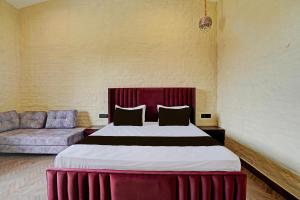 a bedroom with a large bed and a couch at Hotel O New Friends Hotel in Prayagraj