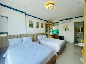 a bedroom with two beds and a bathroom at Lighthouse Hotel & Apartment Phan rang in Kinh Dinh
