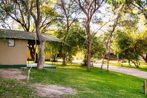 a building in a park with trees and grass at Zambezi Mubala Campsite in Katima Mulilo