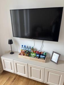a flat screen tv hanging on a wall above a white cabinet at MainApartment 1A in Margetshöchheim +6 photos