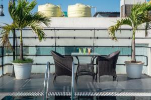 a table and chairs on a balcony with palm trees at Hotel Bhaskar-Near Jaipur Airport in Jaipur