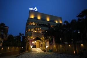 a building with a clock tower at night at Hotel Sangiliyan in Jaffna