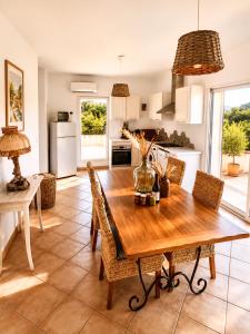 a kitchen and dining room with a wooden table and chairs at L'Alivi di l'Osari in Belgodère