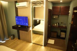 a bathroom with a computer monitor on a desk in a room at Hotel Sangiliyan in Jaffna