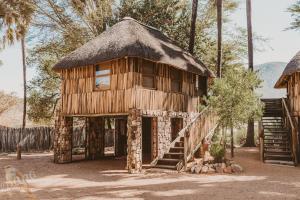a large wooden building with a thatch roof at Epupa Falls Lodge in Epupa