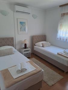 a bedroom with two beds and a table with a lamp at Villa Panorama Blagaj in Blagaj