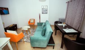 ein Wohnzimmer mit einem blauen Sofa und einem Tisch in der Unterkunft Hotel Djigui in Abidjan