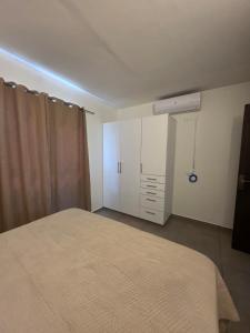 a bedroom with a bed and a closet and a white bed sqor at Duplex en Luque in Zarate Isla