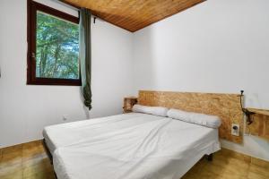 a bedroom with a white bed with a window at 11.Les tilleuls option Clim -6 pers in Calviac