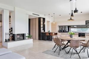 a kitchen and dining room with a table and a fireplace at Linde Villas in Maria Wörth