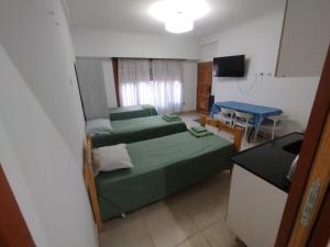 a small room with two beds and a table at Aprt Belgrano 658 in Neuquén