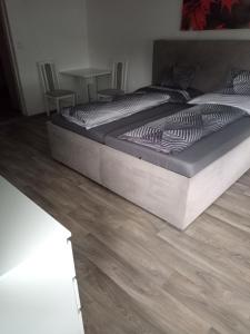 a large bed in a bedroom with a wooden floor at Pohádka in Kunratice +6 photos