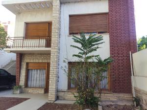 a house with a tree in front of it at Aprt Belgrano 658 in Neuquén