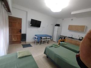 a room with two beds and a kitchen with a table at Aprt Belgrano 658 in Neuquén