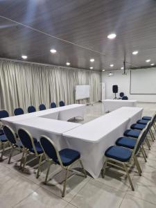 ein Konferenzraum mit einem großen weißen Tisch und Stühlen in der Unterkunft Hotel Djigui in Abidjan
