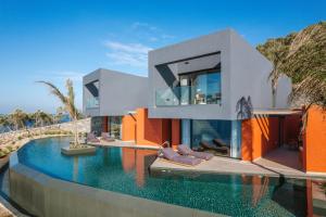 a house with a swimming pool next to a house at River Villas Plomari - Luxury Villas with Direct Pool Access in Plomari
