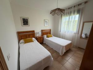 a bedroom with two beds and a window at Chalet privado playa de Boa in Noya