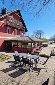 a patio with a table and chairs in front of a building at Penzion Bara in Přední Výtoň