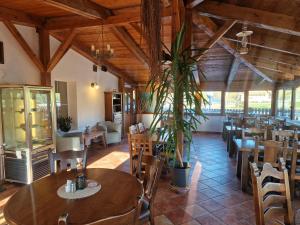 a restaurant with wooden ceilings and tables and chairs at Penzion Bara in Přední Výtoň