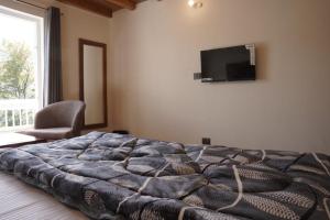 a bedroom with a bed and a tv on the wall at The Oak Lake Cottage Boho in Nainital