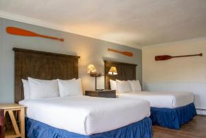 a hotel room with two beds with white sheets at Gauthier's Saranac Lake Inn in Saranac Lake +36 photos