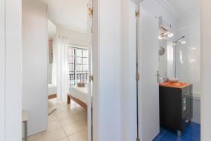 a hallway with a bathroom with a sink and a room at Casa Lori Albufeira in Albufeira