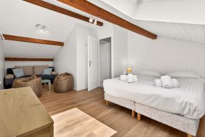 a white bedroom with a bed and a couch at Villa Miroir in Publier +40 photos