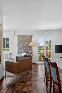 a living room with a couch and a table and chairs at Villa Miroir in Publier