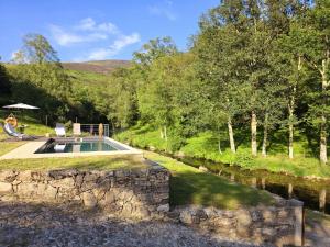 a stone retaining wall next to a swimming pool at Casa Rio D'Além in Melgaço