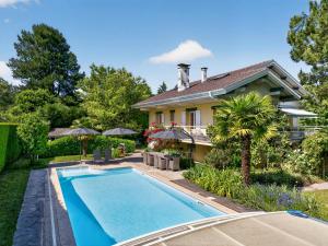 a house with a swimming pool in front of a house at Villa Miroir in Publier