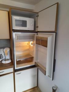 an open refrigerator with a microwave on top of it at Haus Annemiek in Winterberg