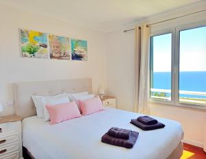 a bedroom with a large white bed with a view of the ocean at Dorisol Vista Formosa by Rentallido in Funchal