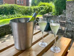 two wine glasses and a bucket with a bottle of champagne at Abbey Cottage in St Bees