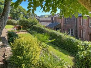 a garden with bushes and a brick building at Abbey Cottage in St Bees +9 photos