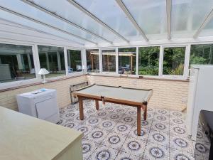 a screened porch with a ping pong table in it at The Nest in Aylsham
