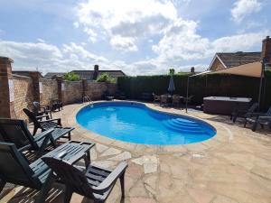 a swimming pool with chairs and a frisbee in it at The Nest in Aylsham +15 photos