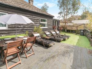 a patio with a table and chairs and an umbrella at By The Beach- Uk31201 in Downderry
