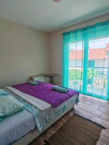 a bedroom with a bed and a large window at Villa Yulia in Luštica