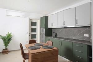 a kitchen with a wooden table and green cabinets at Local View Apartments in Polychrono