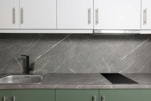 a kitchen counter with a sink and white cabinets at Local View Apartments in Polychrono +3 photos