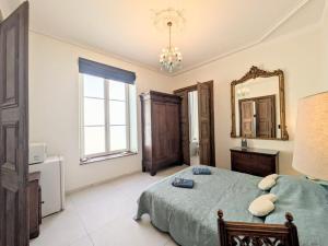 a large bedroom with a bed and a mirror at La chambre de Jeanne in Toul