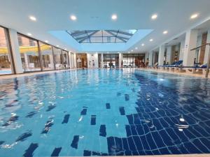 a swimming pool in a building with blue water at 07 Apartment Vlore in Vlorë