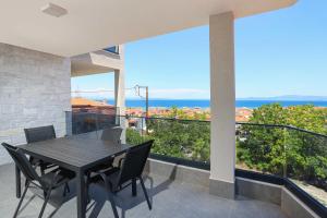a dining table and chairs on a balcony with a view at Local View Apartments in Polychrono